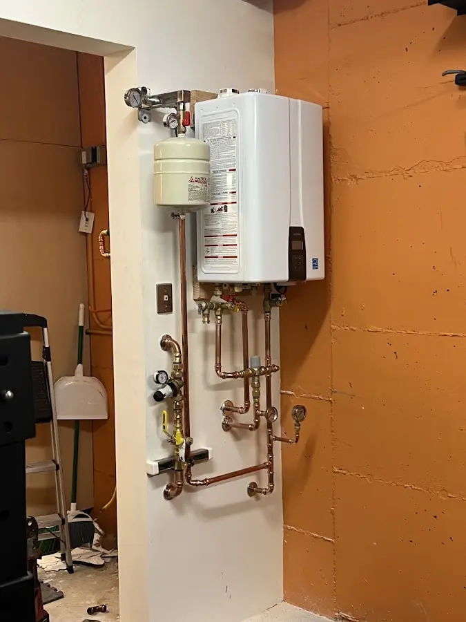 Plumbing technician inspecting water heater connections in Orange Beach
